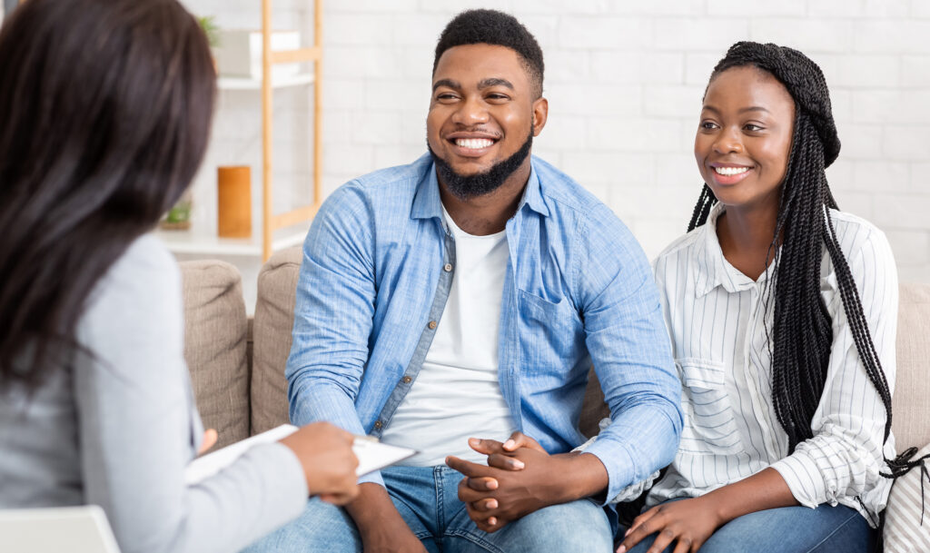 A happy young couple smiling during couples premarital counseling